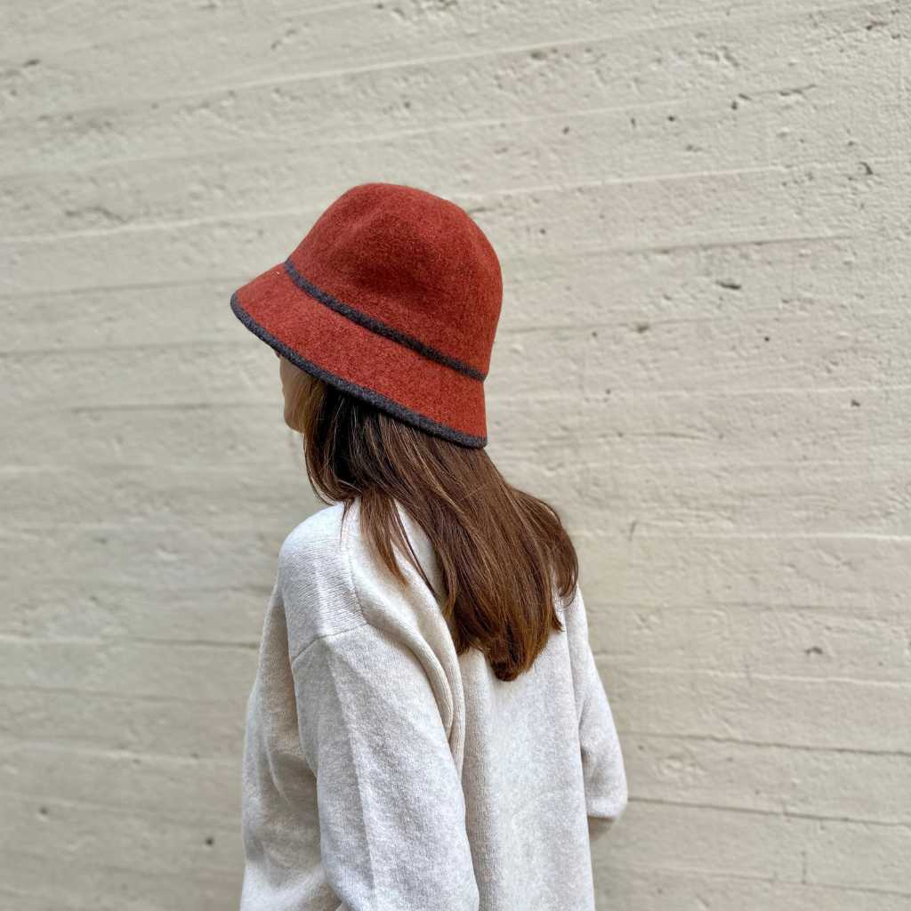 Sombrero de franela en color teja. Tiene marcado el contorno y el inicio de la corona con una línea de color marrón oscuro