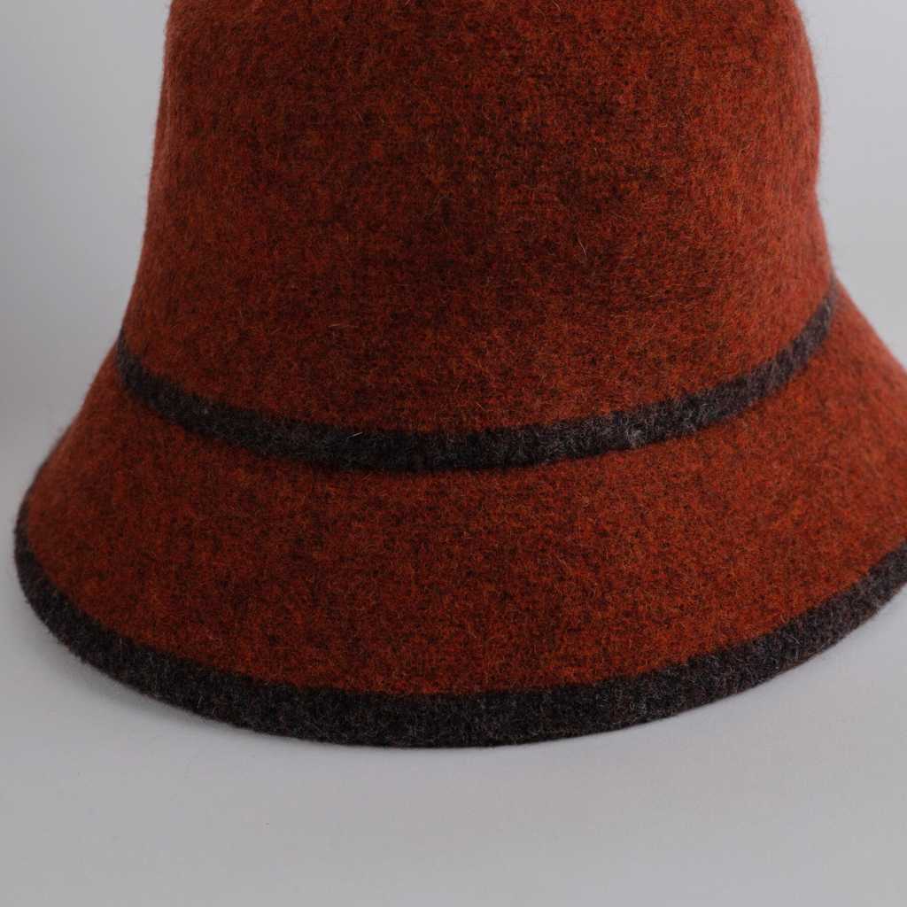 Sombrero de franela en colors teja. Tienen marcado el contorno y el inicio de la corona con una línea de color marrón oscuro
